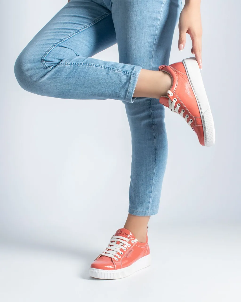 Tênis de couro envernizado coral com solado branco e jeans claro — calçados para fabricantes e distribuidores que vendem no atacado com sua loja B2B VendasxAtacado